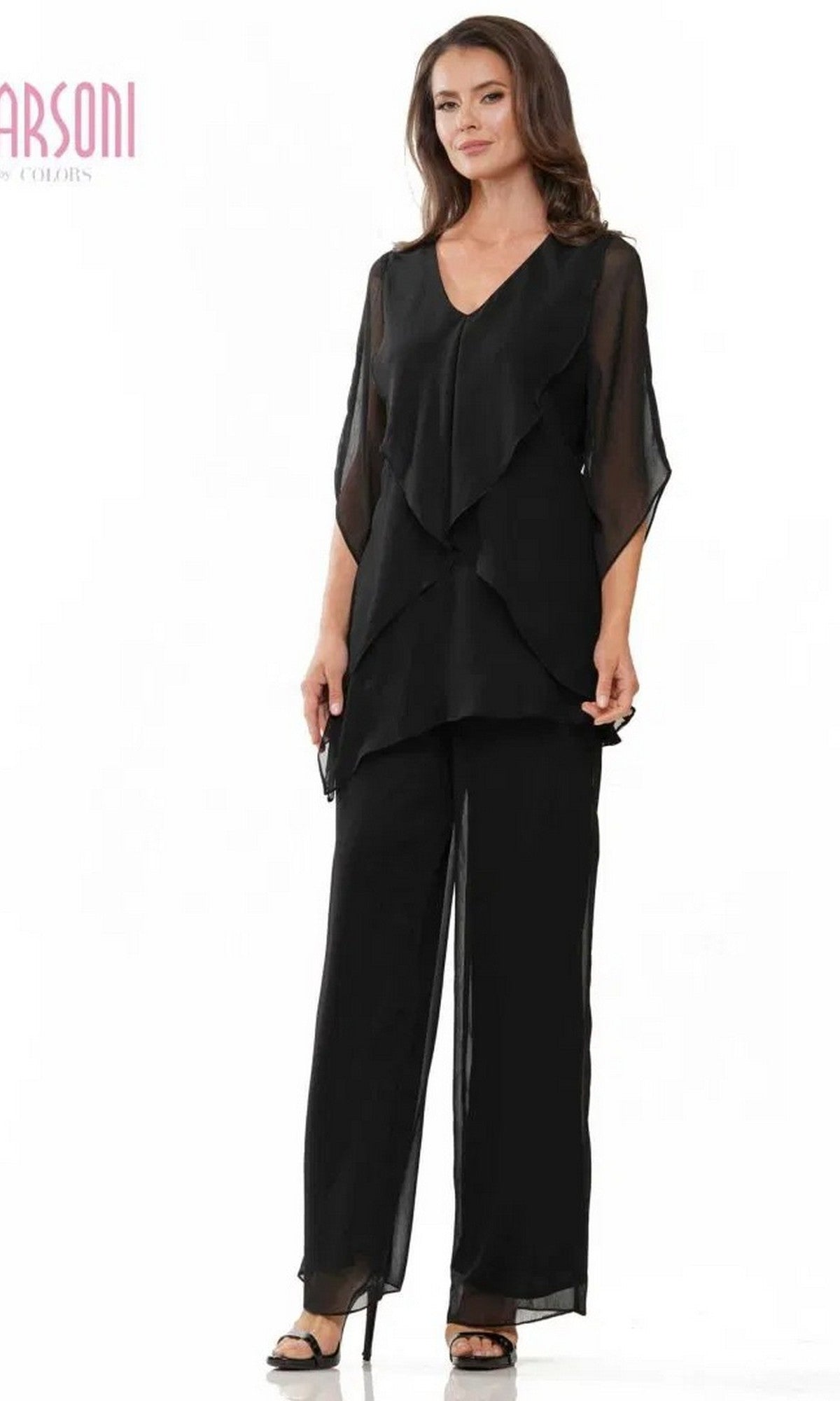 A woman wears the Marsoni M308 long formal black pantsuit, featuring a layered chiffon tunic with sheer sleeves and matching black pants, styled with black open-toe heels.